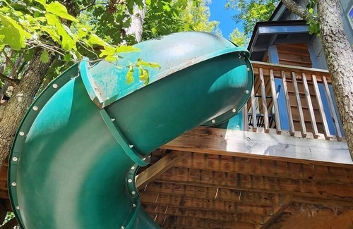 Mill Spring Cabin | 2-story treehouse with a cargo net connecting the upstairs lofts, a large balcony with a slide to the ground level, sleeps 10.