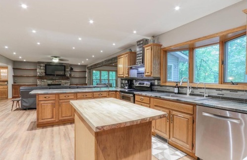 Waupaca House | A beautiful recently remodeled home nested on a wooded river lot with a hot tub.