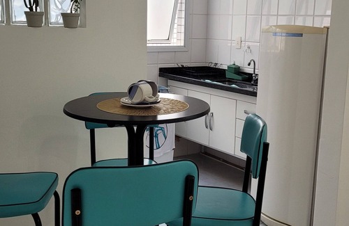 Mongagua Apartment | Apartamento moderninho, com sacada de frente para o mar. Sala bem iluminada.