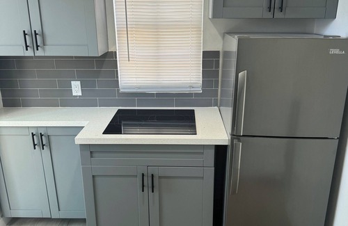 Liberty City House | Modern home with driveway parking and fenced yard.