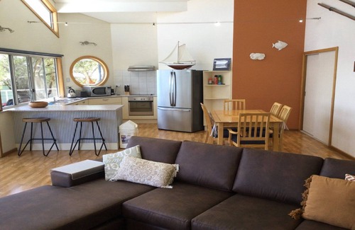 Lake Wangary House | Rest A Shore is a waterfront property with spacious living and north facing panoramic view over the bay from the front deck.