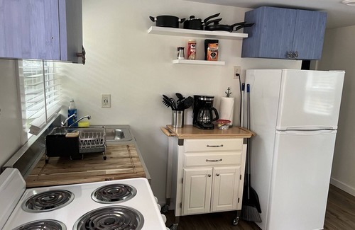 Inglis Apartment | Step into this cozy 2-bedroom cabin nestled in the tranquil woods. The main living area offers comfy seating, including a pull-out futon for additional sleeping space. An efficiency kitchen awaits your culinary adventures, equipped with essentials fo