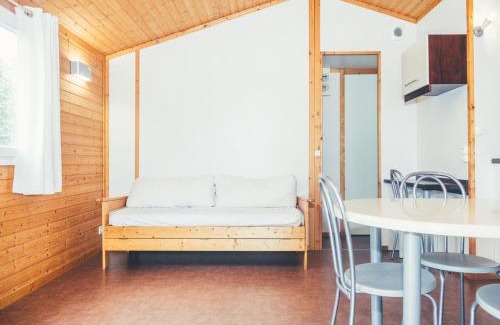 Beynat Ski Chalet | Wooden chalet with covered terrace on the edge of a lake