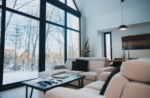 Large windowed chalet surrounded by nature
