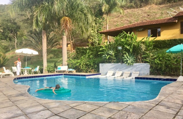 Private waterfall in the garden, swimming pool with small beach and stream with natural pool