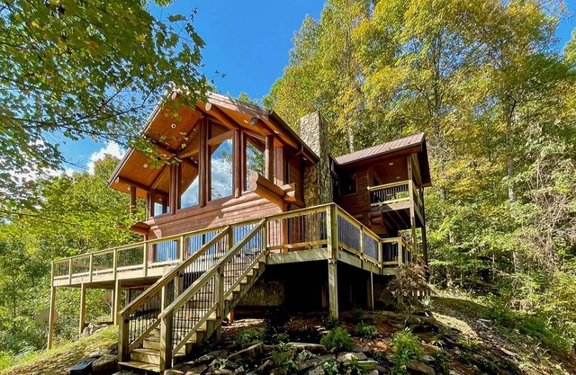 Secluded log cabin with fireplace and hot tub on deck.