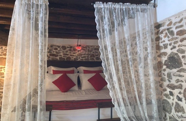 Traditional stone built single room house with traditional bed.