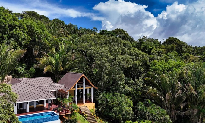 Gibson Bight House | Relax at this hillside retreat that overlooks the lush forest and the Caribbean.