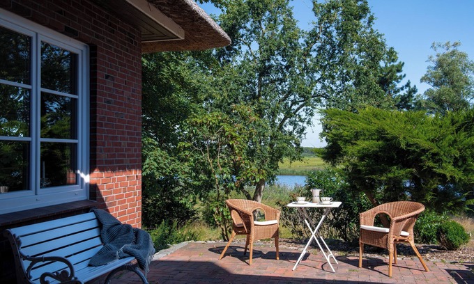 Breiholz House | Right on the water: large thatched house with garden and fireplace